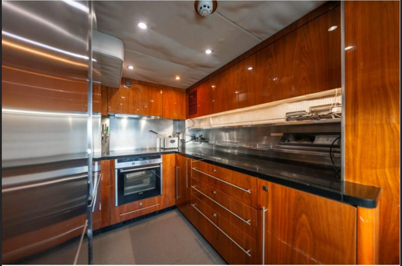 The yacht's galley features sleek wooden cabinetry and modern stainless steel appliances. aboard ARAGO Yacht for Sale