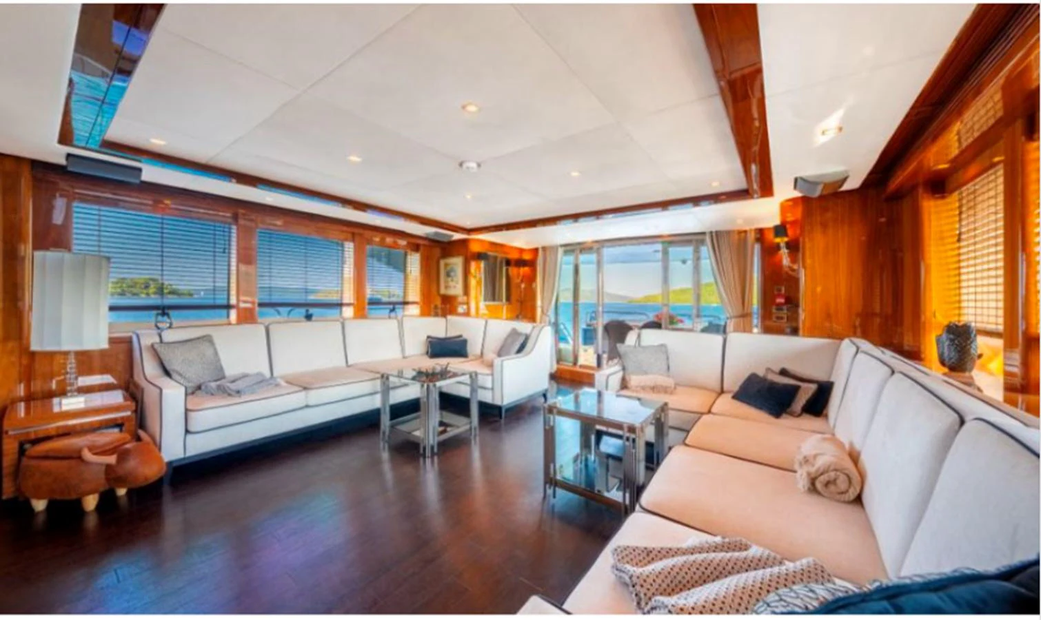 The spacious salon features luxurious seating with panoramic windows offering stunning views. aboard ARAGO Yacht for Sale