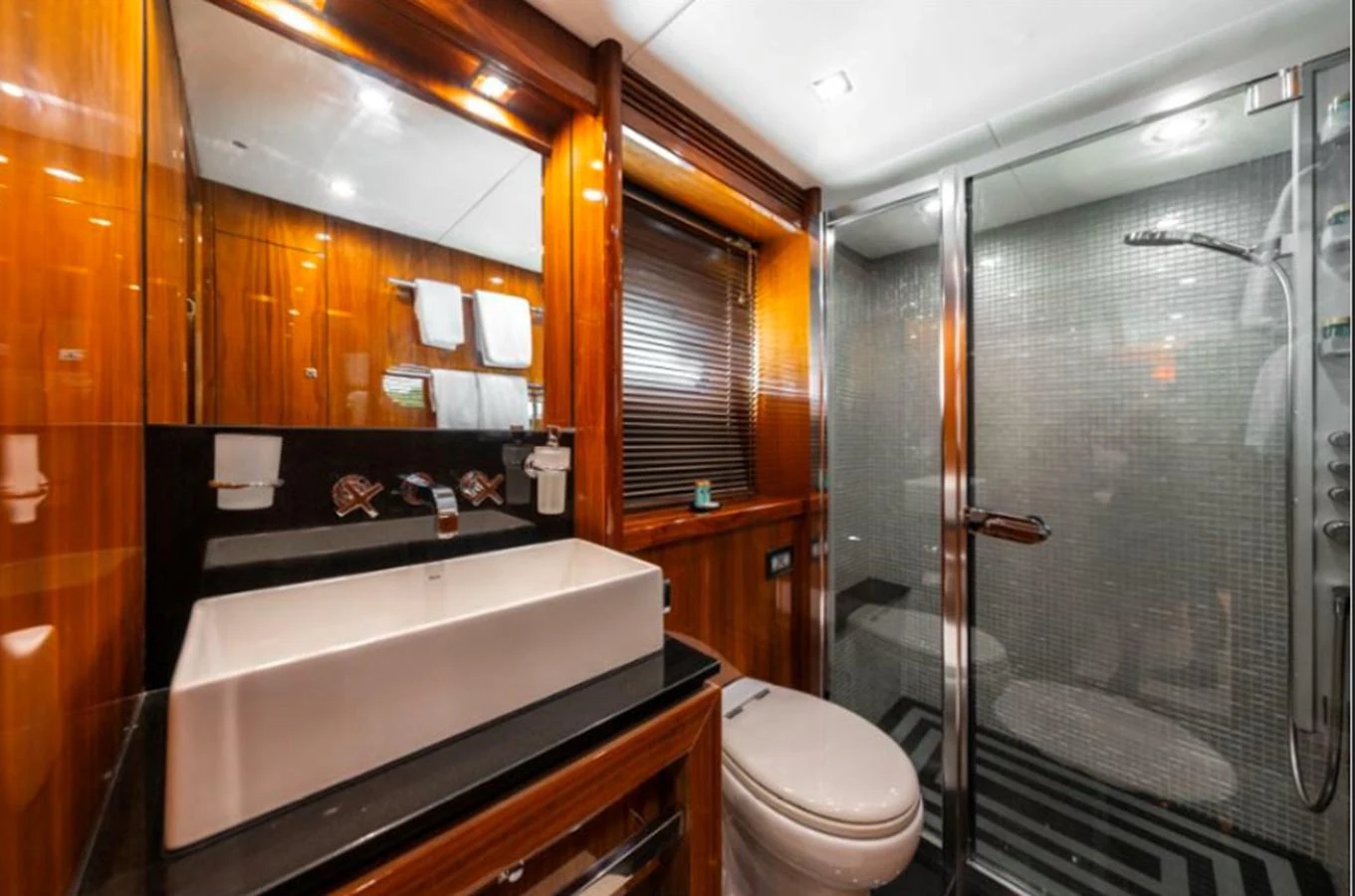 The yacht's bathroom features a sleek design with a glass-enclosed shower and modern fixtures. aboard ARAGO Yacht for Sale