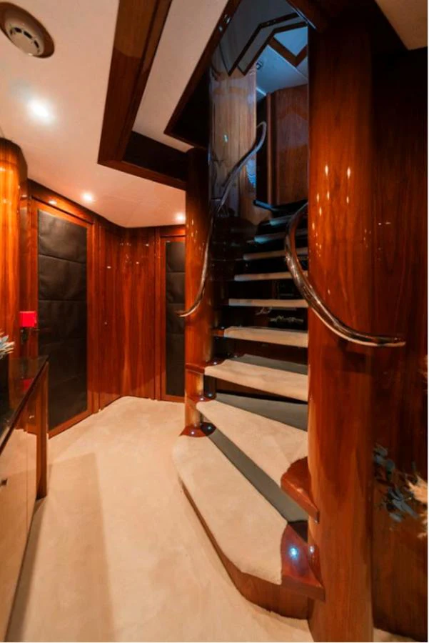 A luxurious interior staircase with polished wood and modern lighting. aboard ARAGO Yacht for Sale
