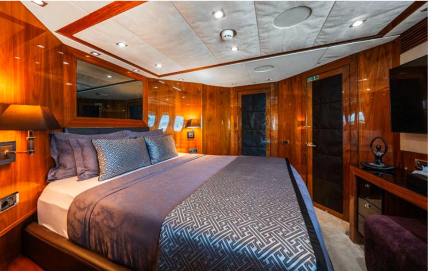 The master stateroom features luxurious bedding and rich wood paneling, creating an inviting and elegant atmosphere. aboard ARAGO Yacht for Sale