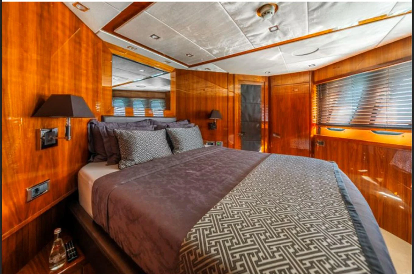The stateroom features luxurious wood paneling and a plush bed with elegant linens. aboard ARAGO Yacht for Sale