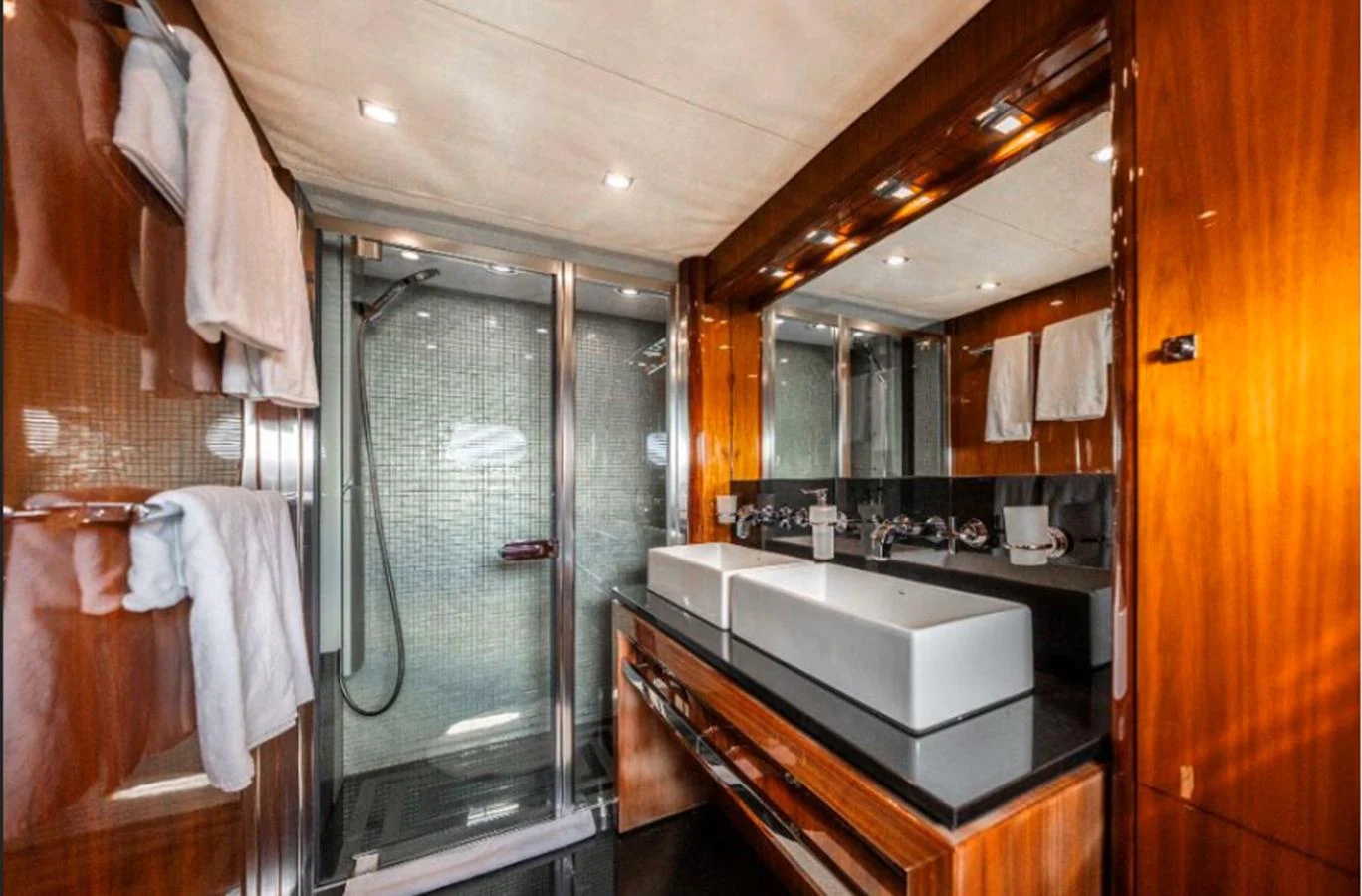 The yacht's bathroom features a sleek design with dual sinks and a spacious shower area. aboard ARAGO Yacht for Sale