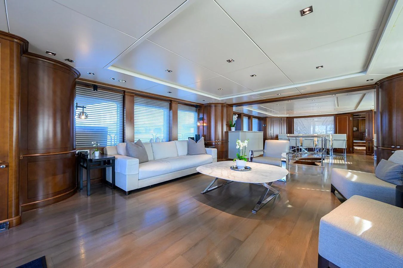 The spacious salon features elegant wood paneling, plush seating, and a modern coffee table, creating a luxurious and inviting atmosphere. aboard BENETTI CLASSIC Yacht for Sale