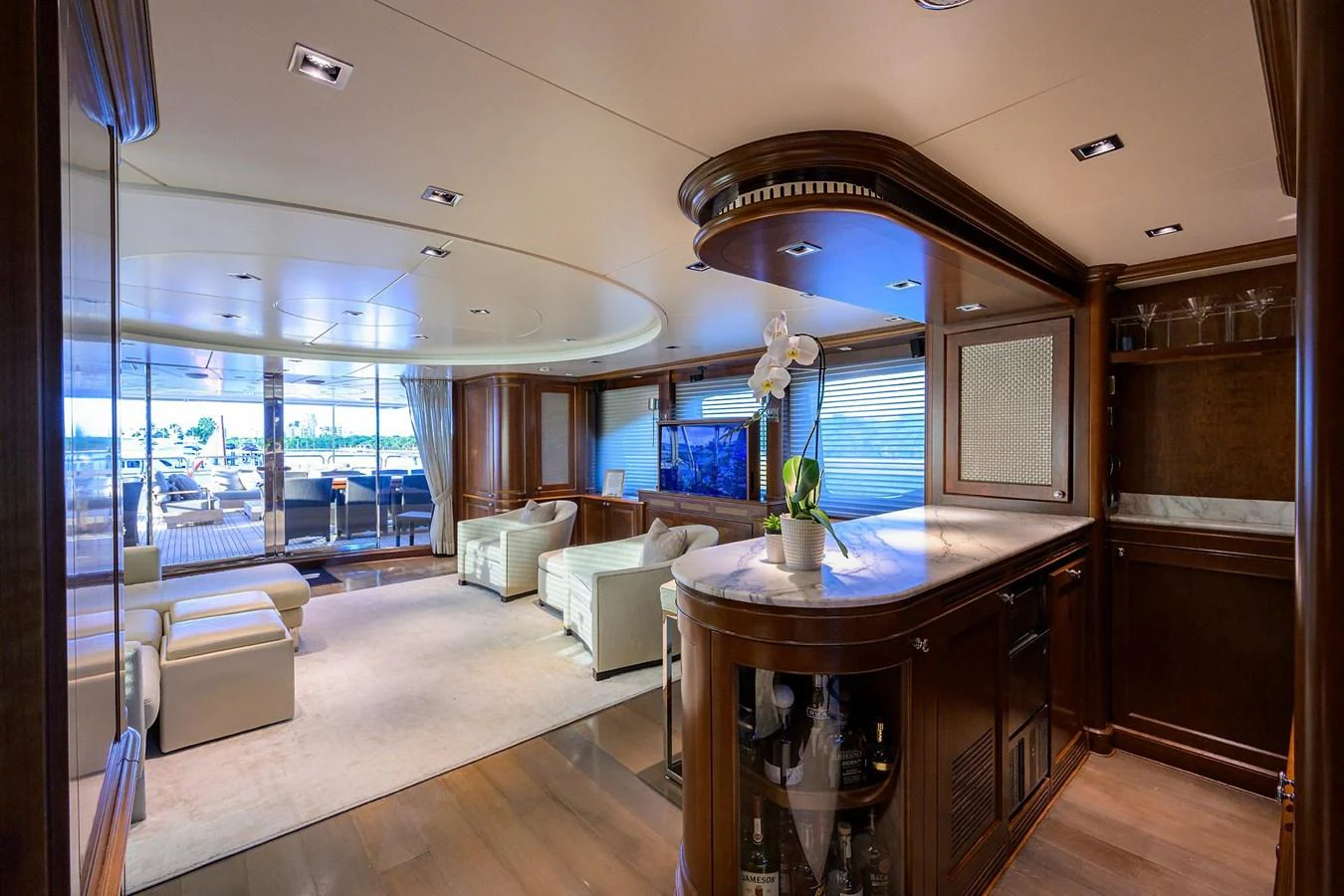 The yacht's salon features elegant seating, a bar area, and large windows offering panoramic views. aboard BENETTI CLASSIC Yacht for Sale