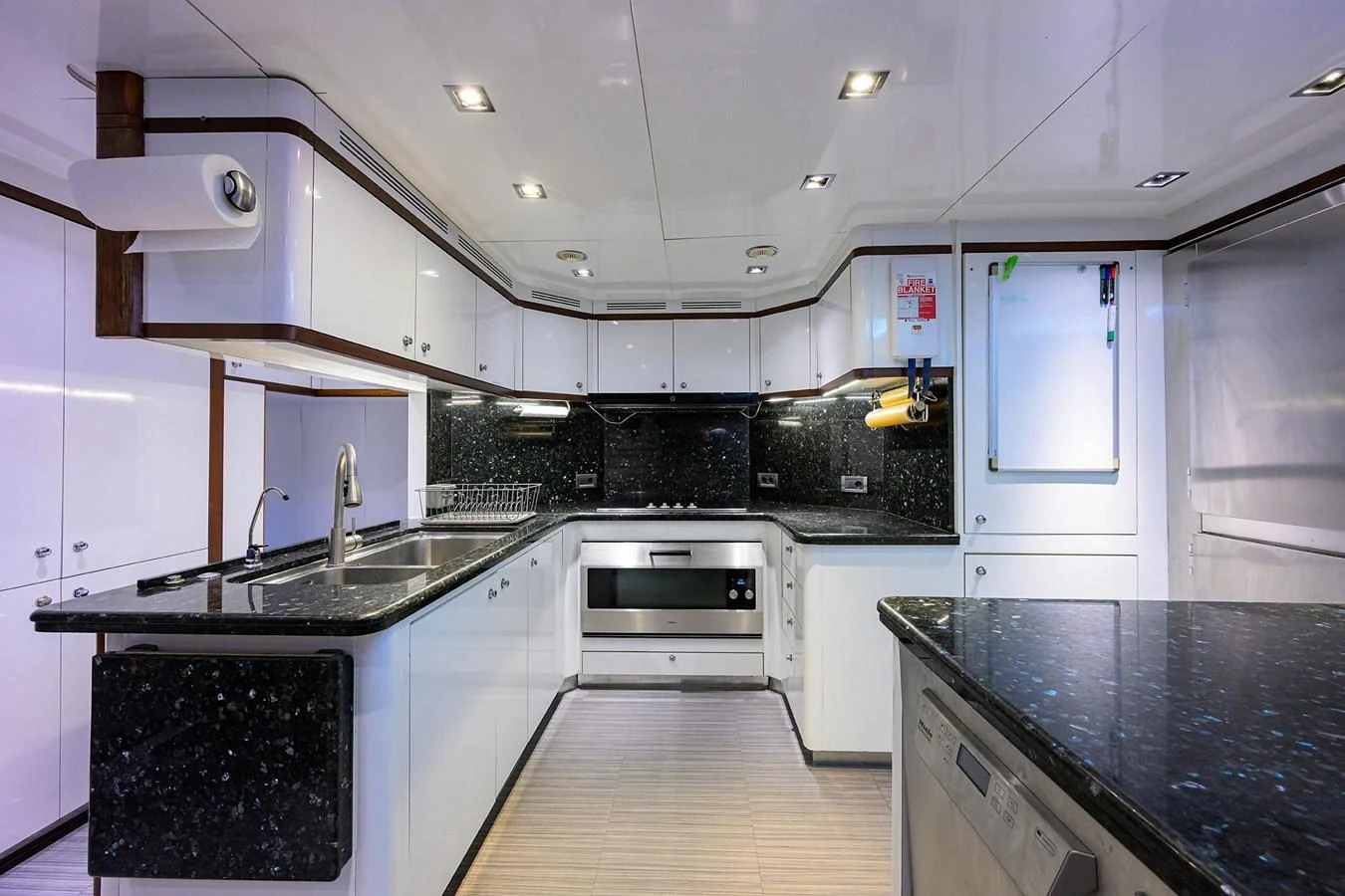 The yacht's galley features modern appliances and sleek black countertops, creating a stylish and functional cooking space. aboard BENETTI CLASSIC Yacht for Sale