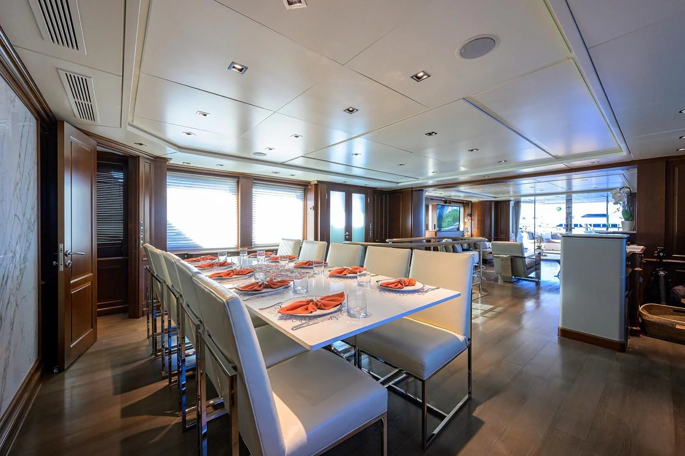 The yacht's dining area features a long table with elegant place settings, surrounded by comfortable seating and ample natural light. aboard BENETTI CLASSIC Yacht for Sale