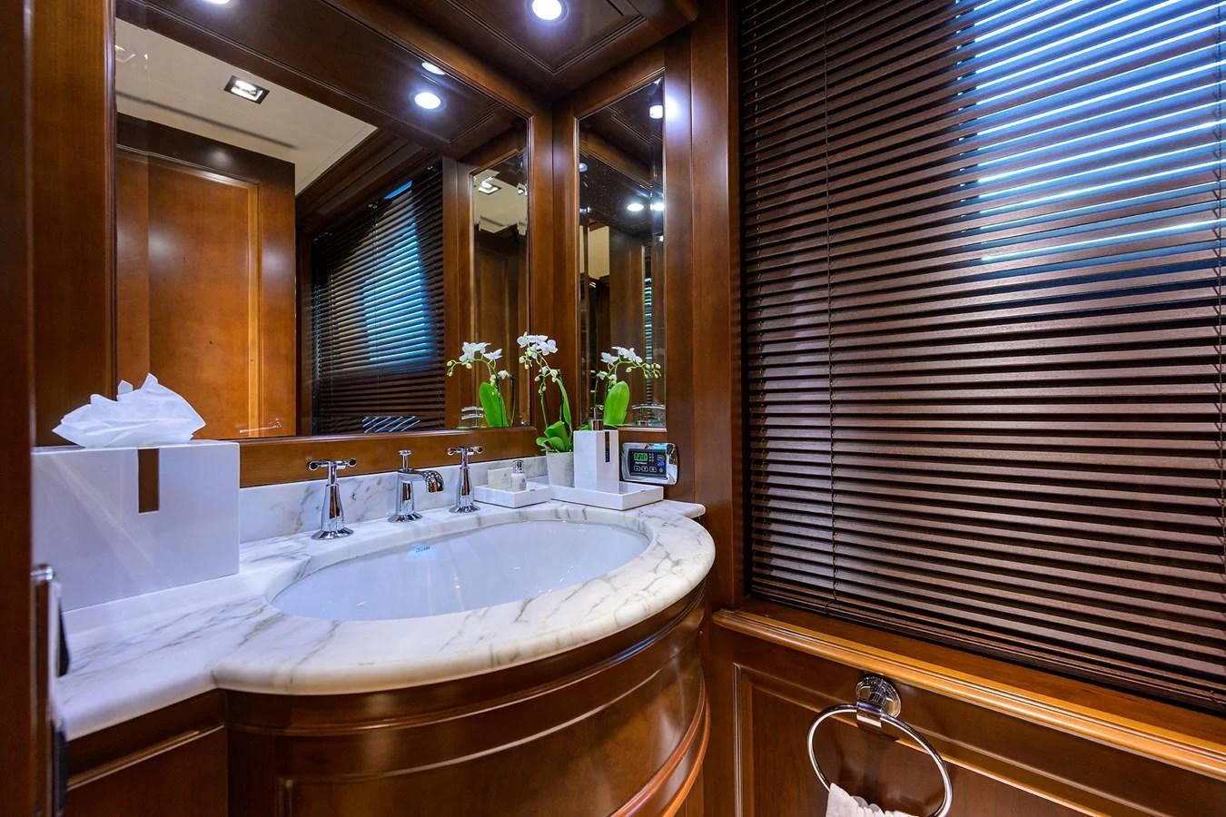 The yacht's bathroom features elegant wood paneling and a marble countertop with modern fixtures. aboard BENETTI CLASSIC Yacht for Sale