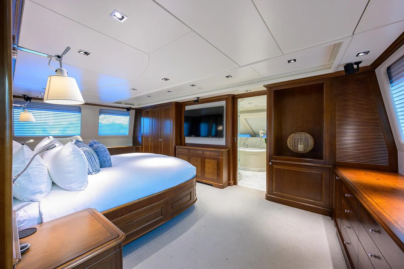 The master stateroom features elegant wood paneling, a large bed, and ample natural light. aboard BENETTI CLASSIC Yacht for Sale