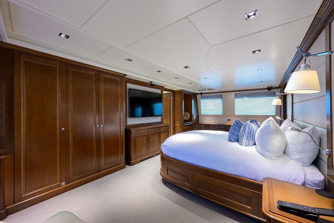 The master stateroom features elegant wood paneling and a spacious, comfortable bed. aboard BENETTI CLASSIC Yacht for Sale