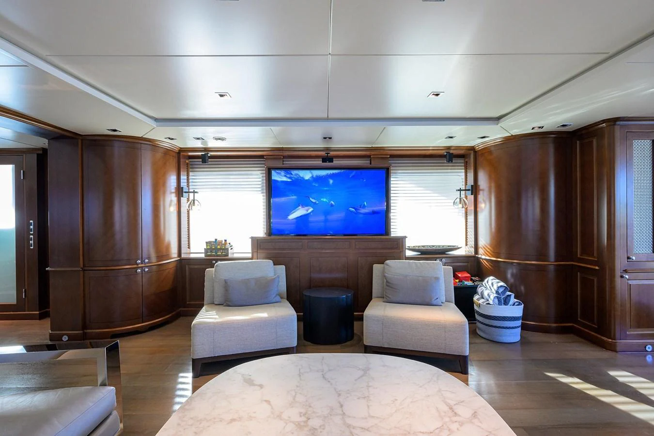The yacht's salon features elegant wood paneling, plush seating, and a large flat-screen TV for entertainment. aboard BENETTI CLASSIC Yacht for Sale