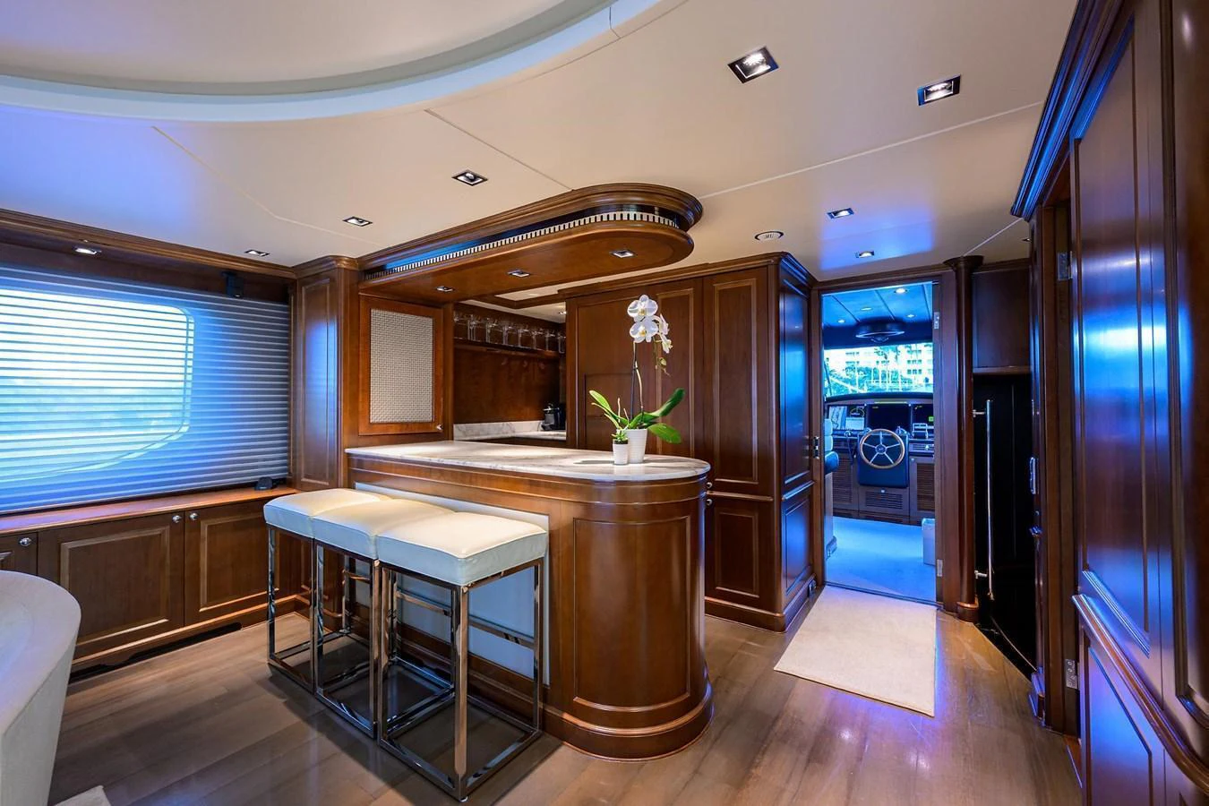 The yacht's galley features elegant wood cabinetry and a sleek bar area with modern stools. aboard BENETTI CLASSIC Yacht for Sale