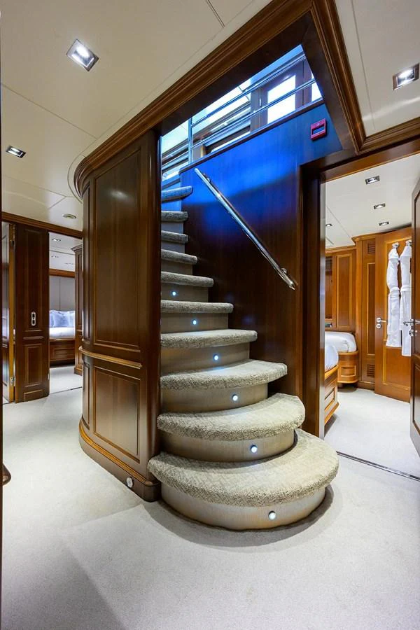 The elegant staircase with plush carpeting and wooden paneling exudes luxury and sophistication. aboard BENETTI CLASSIC Yacht for Sale