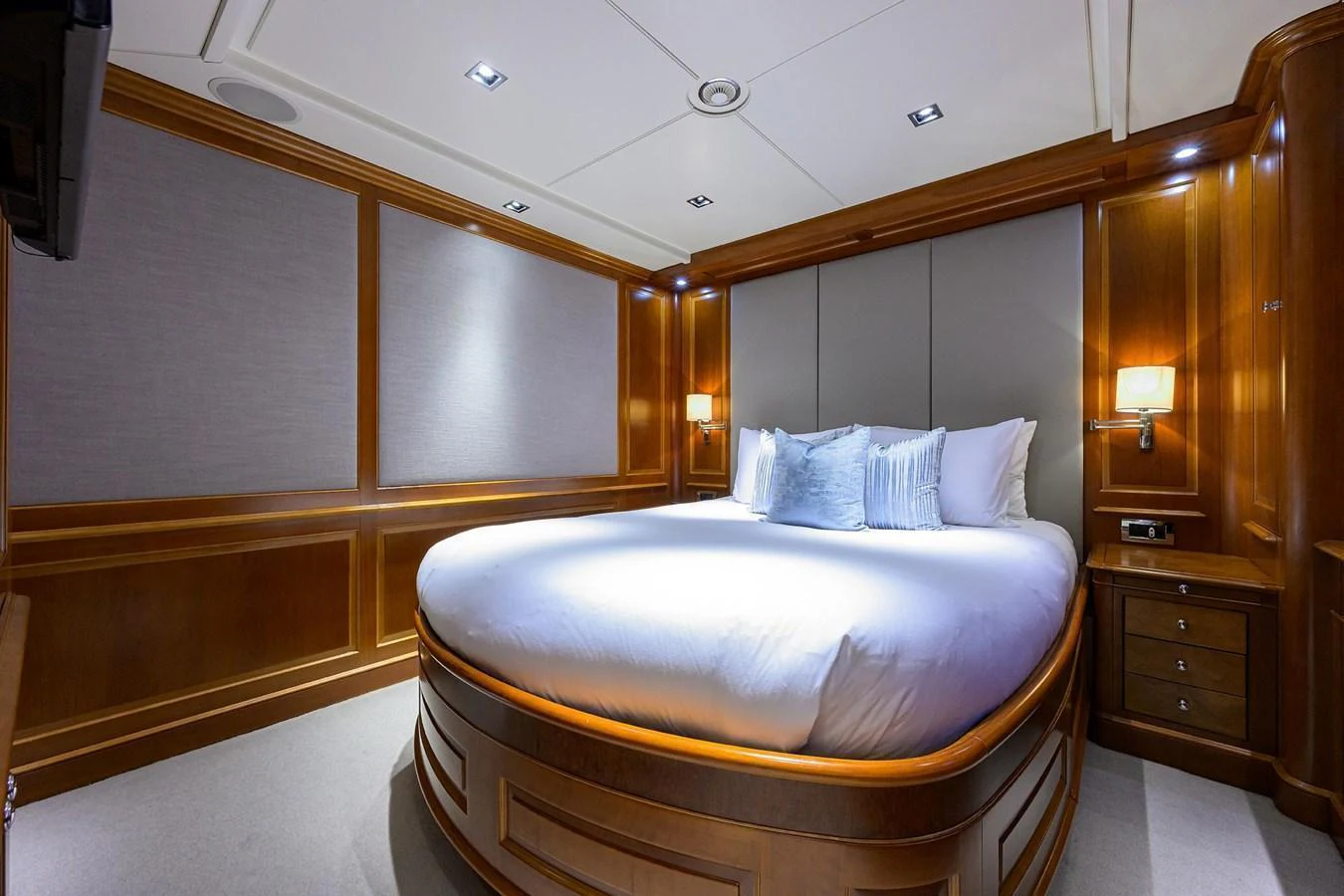The stateroom features a luxurious bed with elegant wood paneling and soft lighting. aboard BENETTI CLASSIC Yacht for Sale