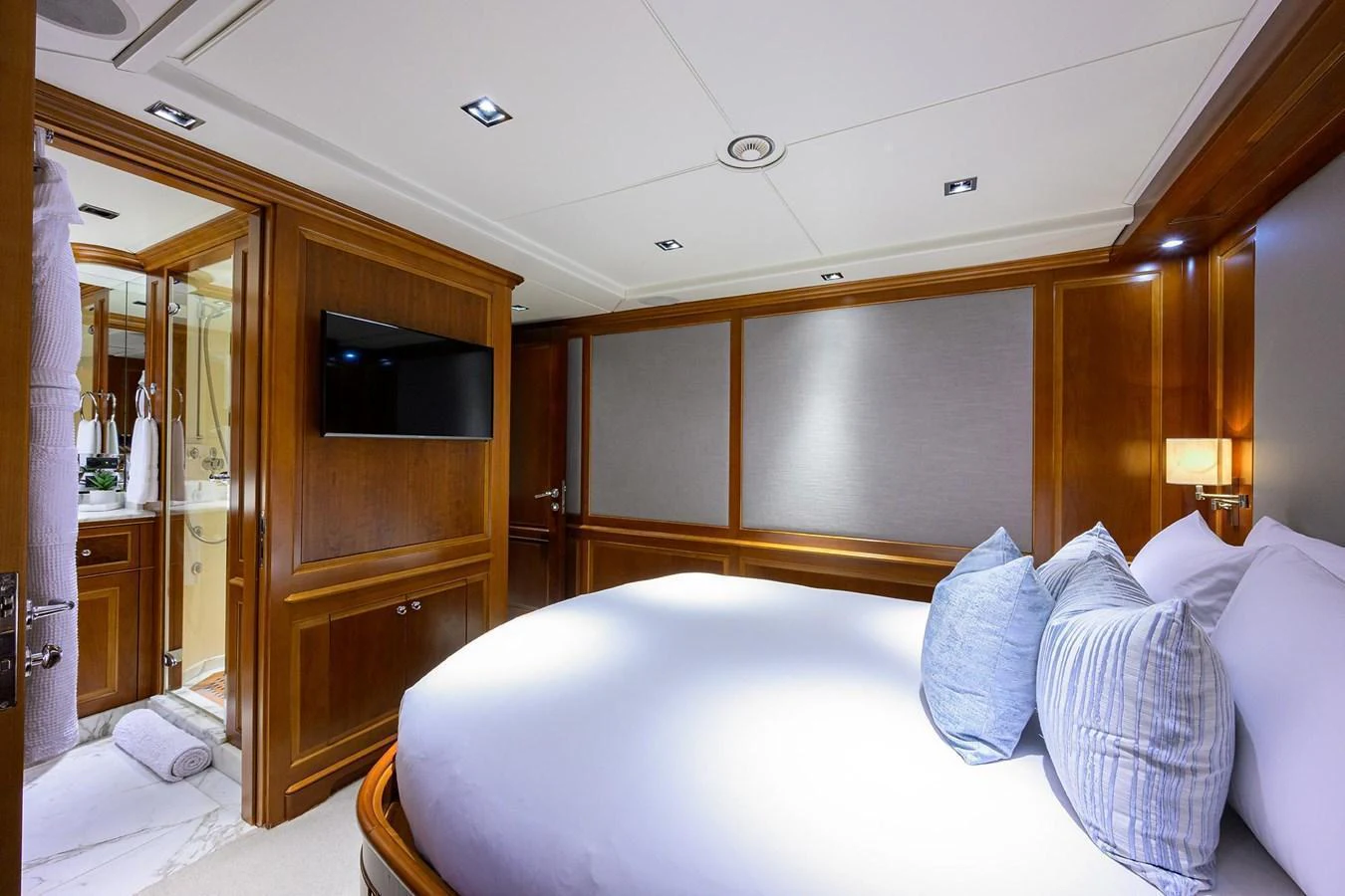 The stateroom features a plush bed with elegant wood paneling and modern amenities. aboard BENETTI CLASSIC Yacht for Sale