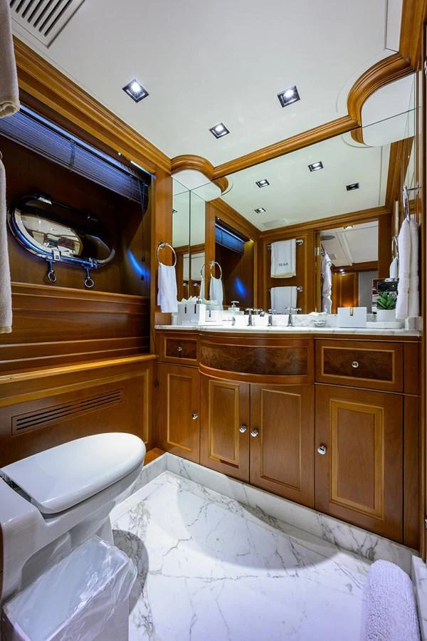 The yacht's bathroom features elegant wood cabinetry and a luxurious marble floor. aboard BENETTI CLASSIC Yacht for Sale