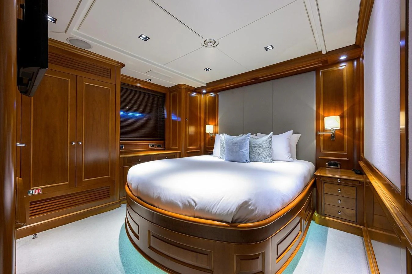 The master stateroom features a luxurious bed with elegant wooden cabinetry and soft lighting. aboard BENETTI CLASSIC Yacht for Sale