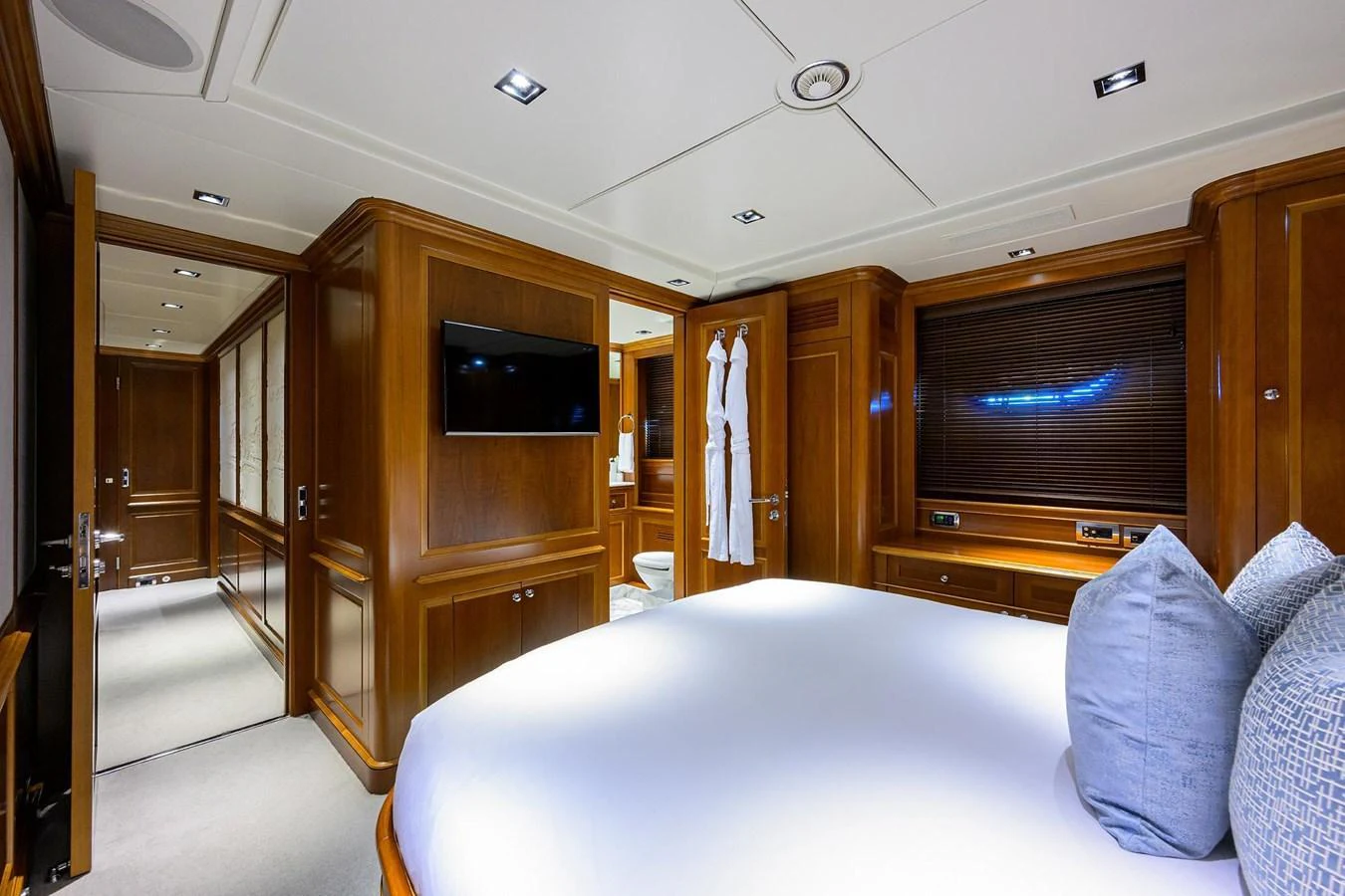 The master stateroom features elegant wood paneling, a plush bed, and modern amenities for ultimate comfort. aboard BENETTI CLASSIC Yacht for Sale