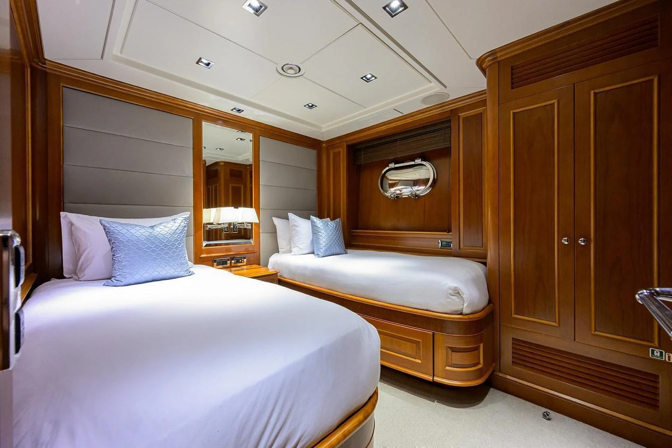 The guest stateroom features twin beds with luxurious bedding and elegant wood paneling. aboard BENETTI CLASSIC Yacht for Sale