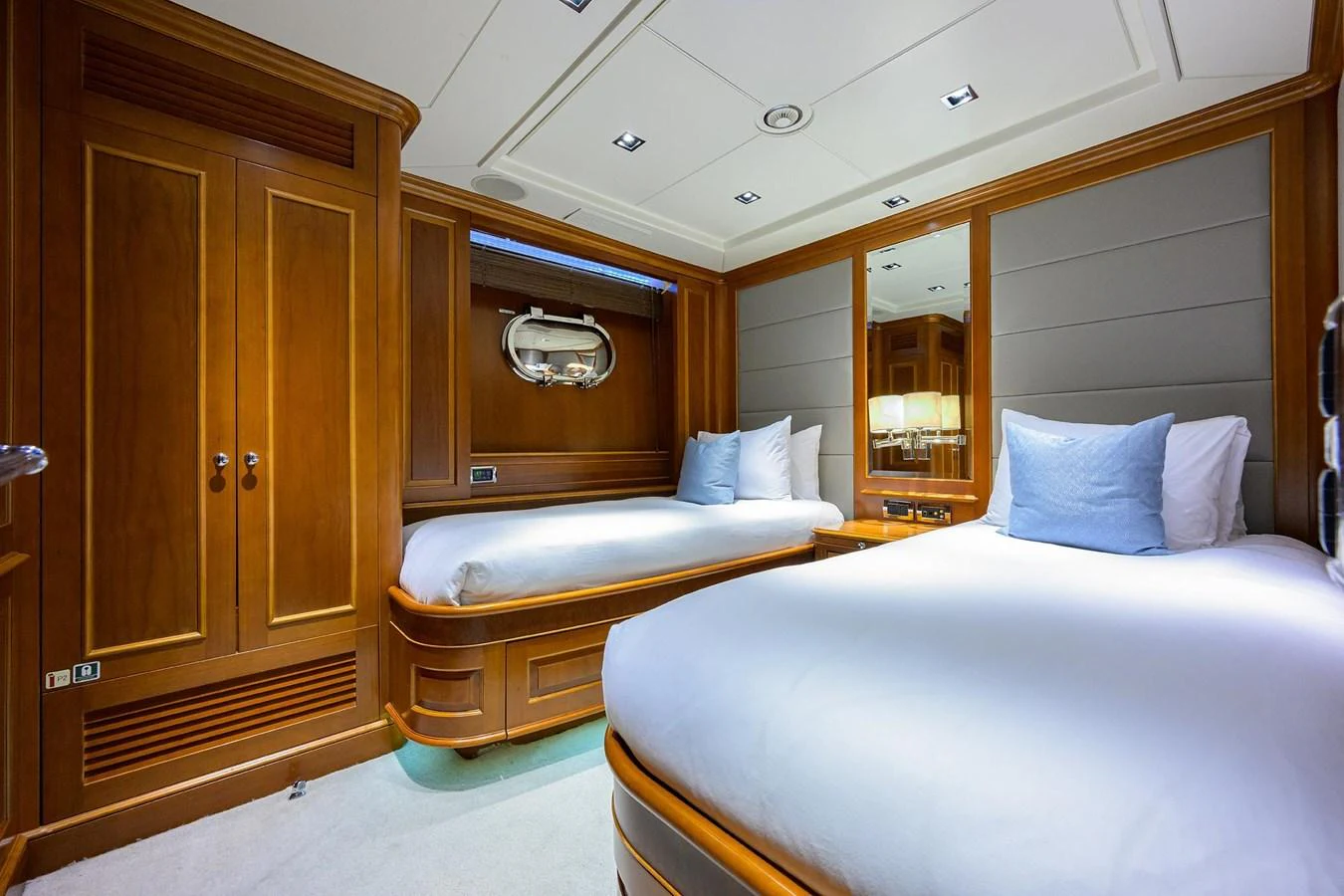 The guest stateroom features twin beds with elegant wooden cabinetry and soft lighting. aboard BENETTI CLASSIC Yacht for Sale