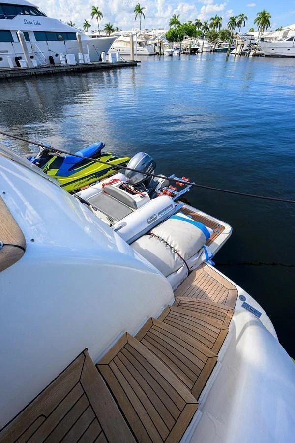 The image showcases the yacht's swim platform with a tender and jet skis docked nearby. aboard BENETTI CLASSIC Yacht for Sale