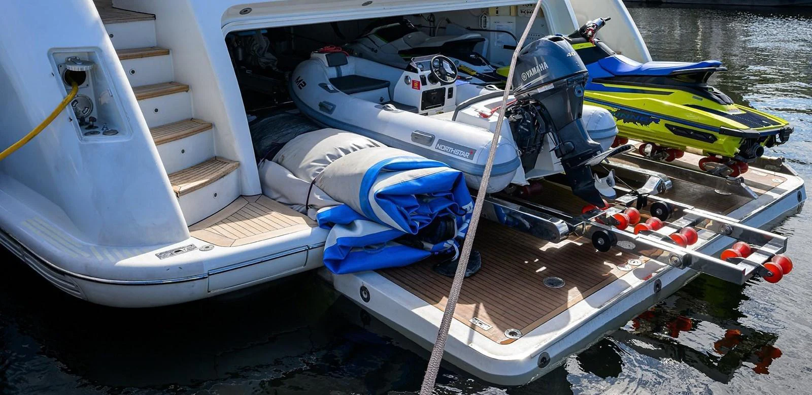 The yacht's garage is equipped with various water toys, including jet skis and an inflatable boat. aboard BENETTI CLASSIC Yacht for Sale