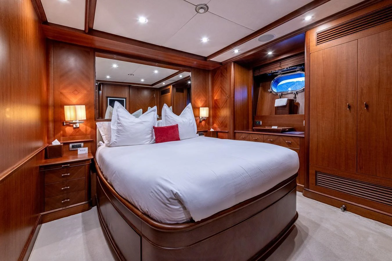 A luxurious stateroom featuring a large bed, rich wood paneling, and elegant lighting. aboard SEA BLUEZ Yacht for Sale