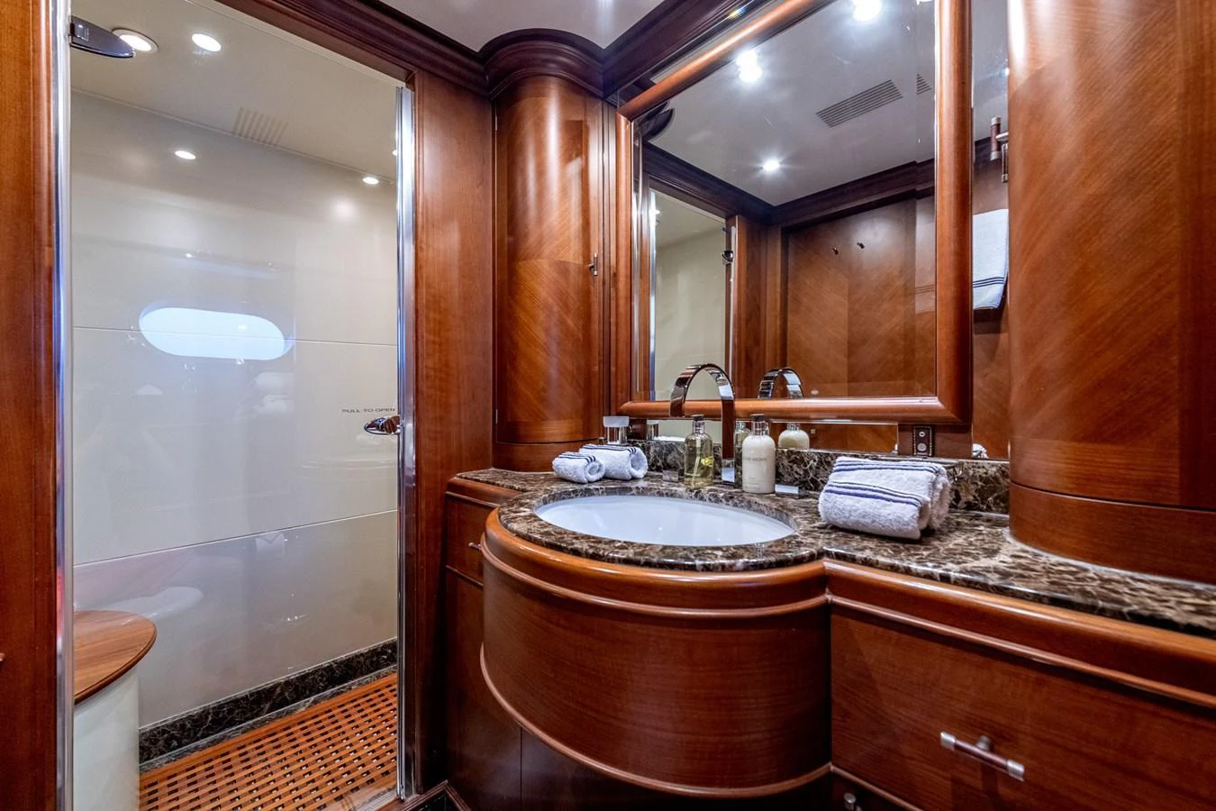 The yacht's bathroom features elegant wood paneling and a luxurious marble countertop. aboard SEA BLUEZ Yacht for Sale