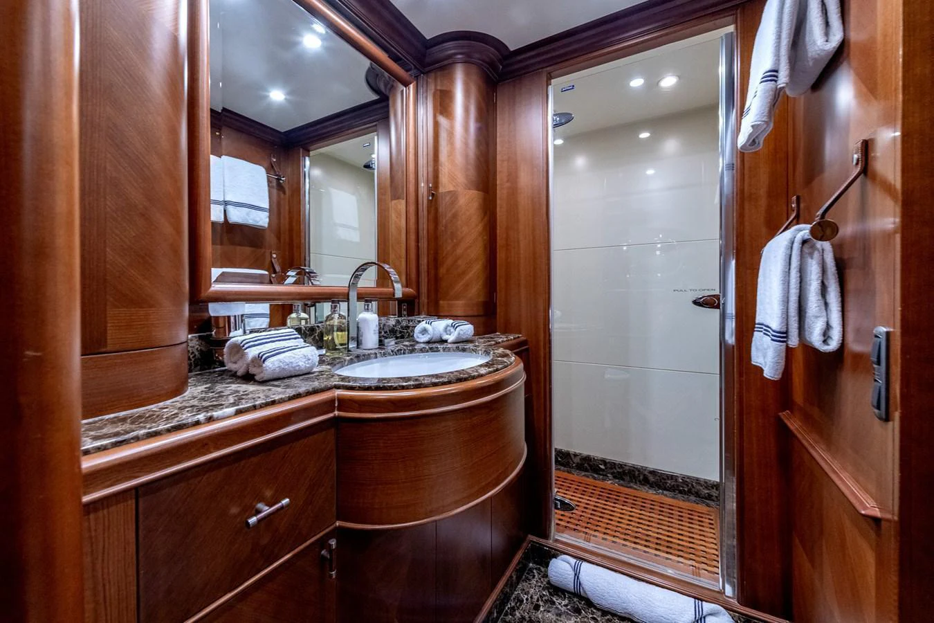 The yacht's bathroom features elegant wood paneling and a luxurious marble countertop. aboard SEA BLUEZ Yacht for Sale