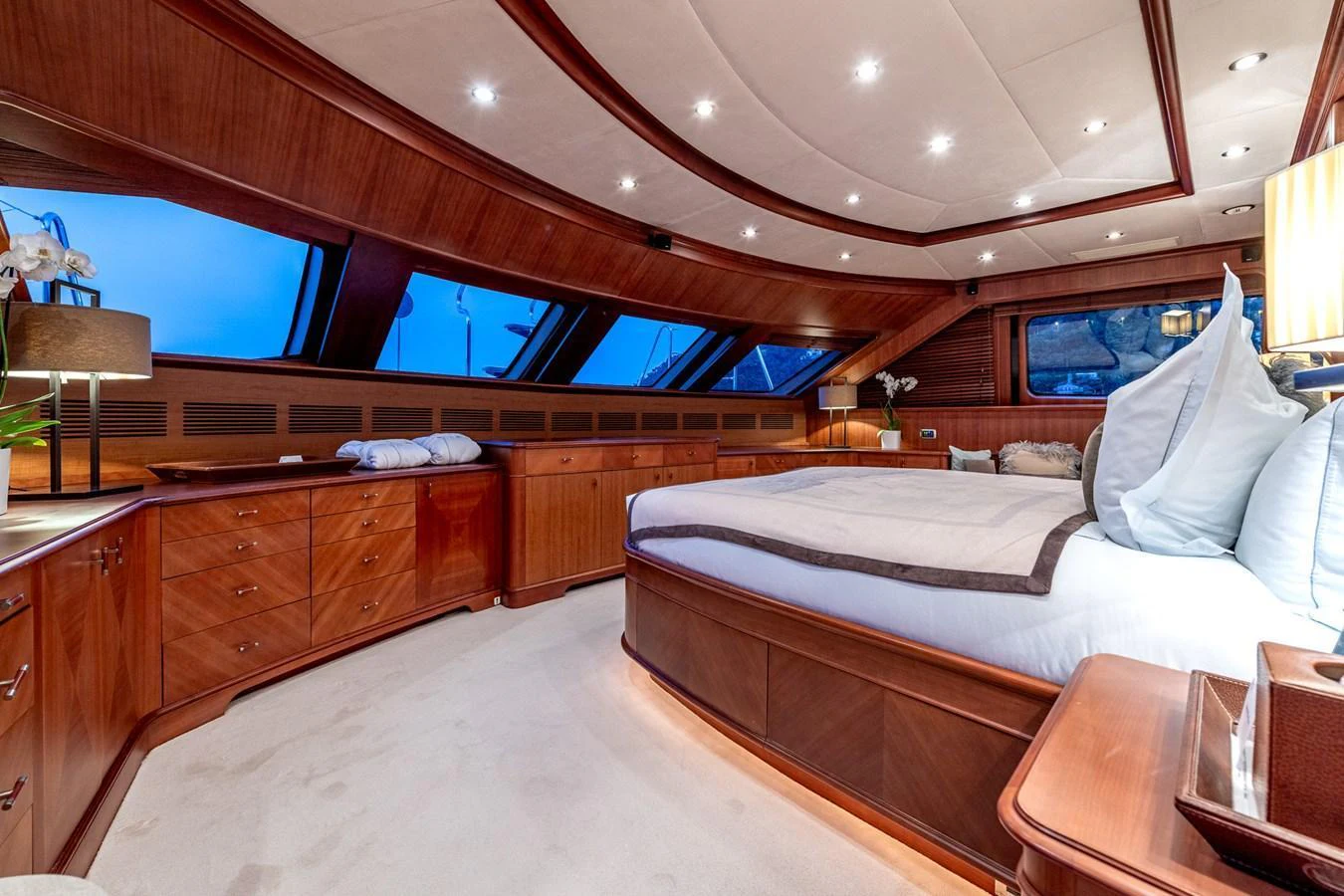 The master stateroom features elegant wood paneling, a large bed, and ample natural light from the windows. aboard SEA BLUEZ Yacht for Sale