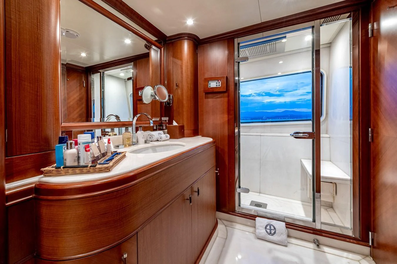 The yacht's bathroom features elegant wooden cabinetry and a spacious shower area with a view. aboard SEA BLUEZ Yacht for Sale
