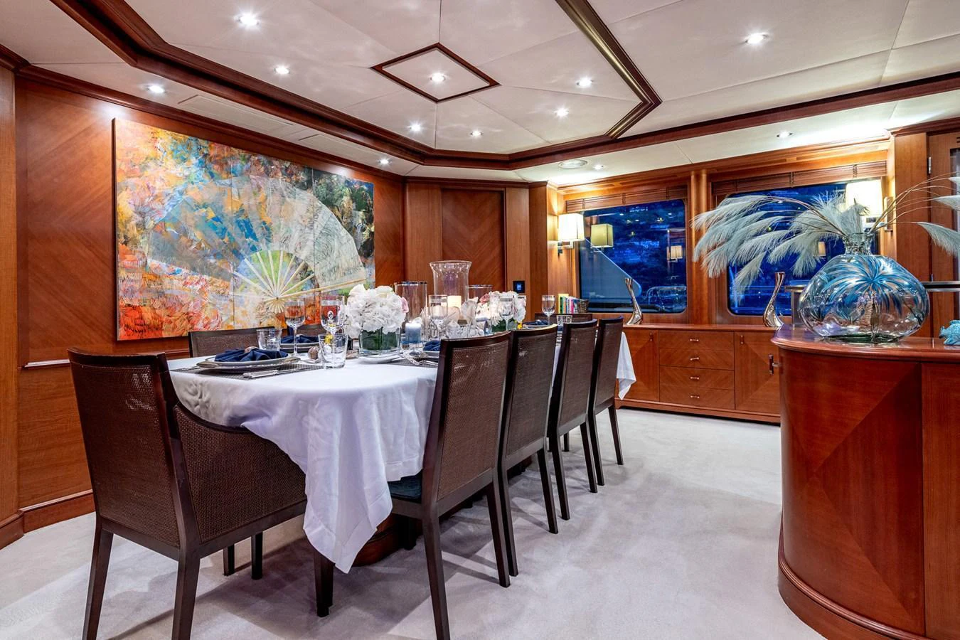 The yacht's dining area features elegant wooden paneling, a large table set for a formal meal, and tasteful artwork. aboard SEA BLUEZ Yacht for Sale