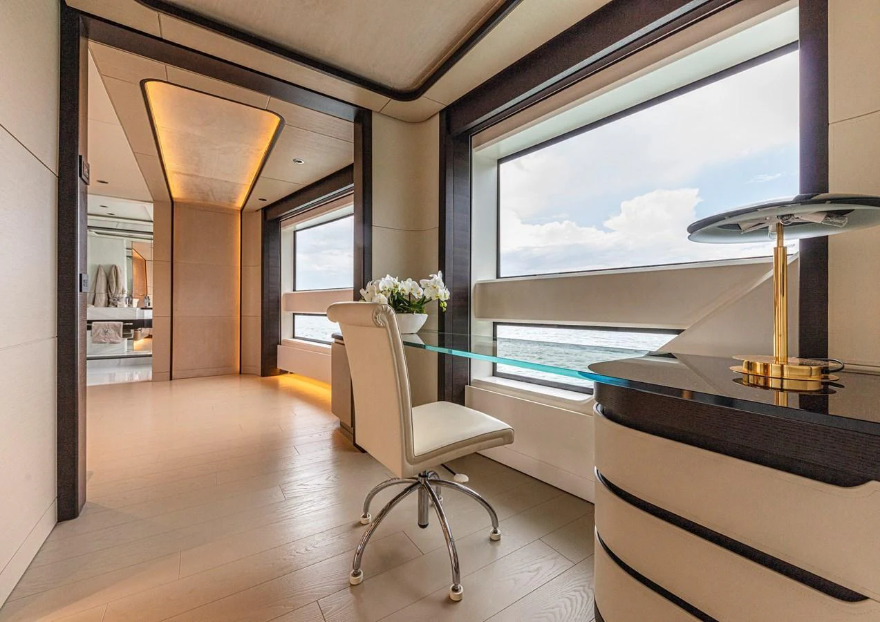 A luxurious interior space featuring a modern desk area with large windows offering stunning ocean views. aboard DUCALE 120 Yacht for Sale