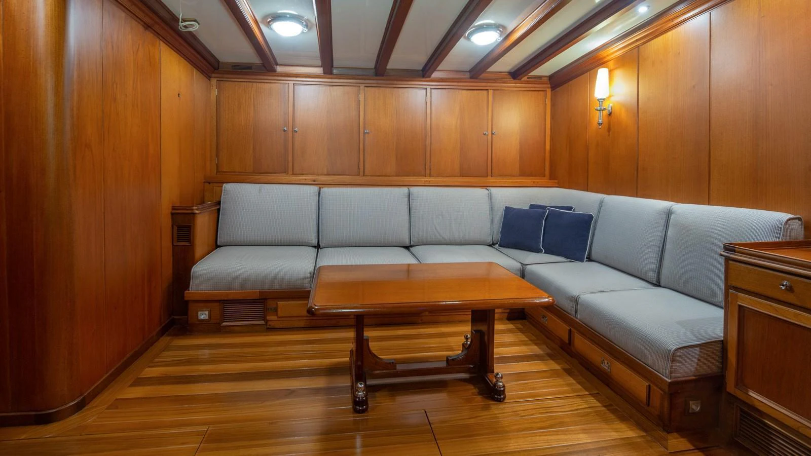 The yacht's interior features a cozy lounge area with wooden paneling and comfortable seating. aboard CANDIDA Yacht for Sale