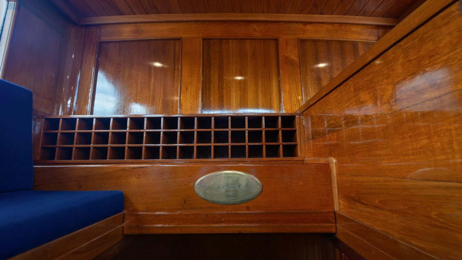 The image showcases a beautifully crafted wooden interior with a wine rack and polished wood panels. aboard CANDIDA Yacht for Sale