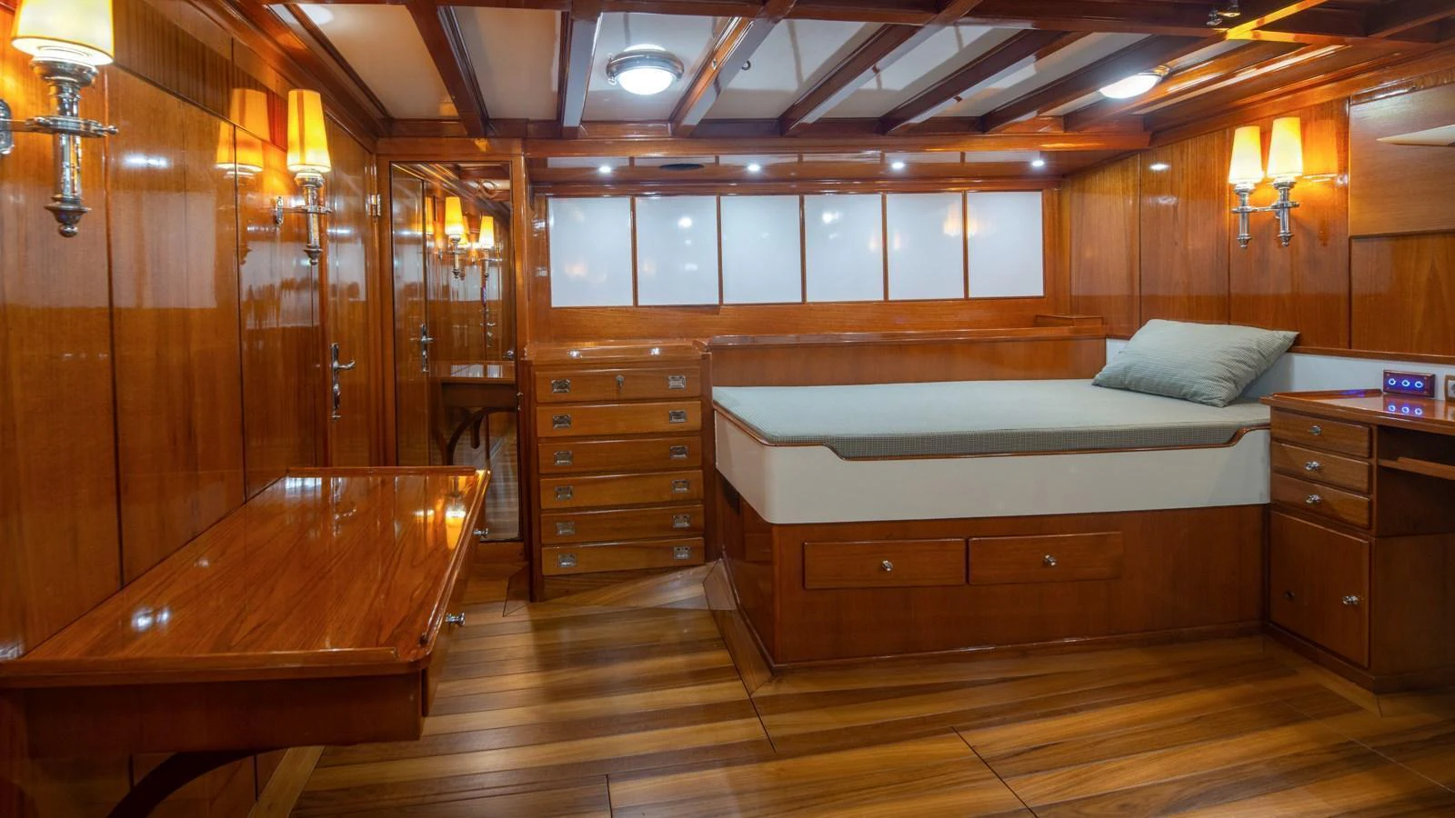 The stateroom features rich wood paneling, ambient lighting, and a comfortable bed. aboard CANDIDA Yacht for Sale