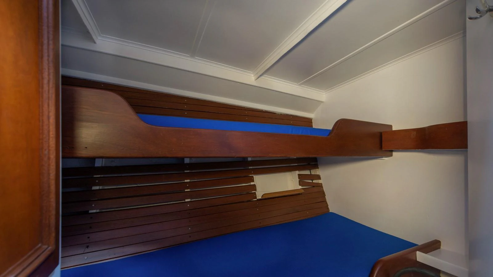 A cozy bunk cabin with wooden accents and blue bedding. aboard CANDIDA Yacht for Sale