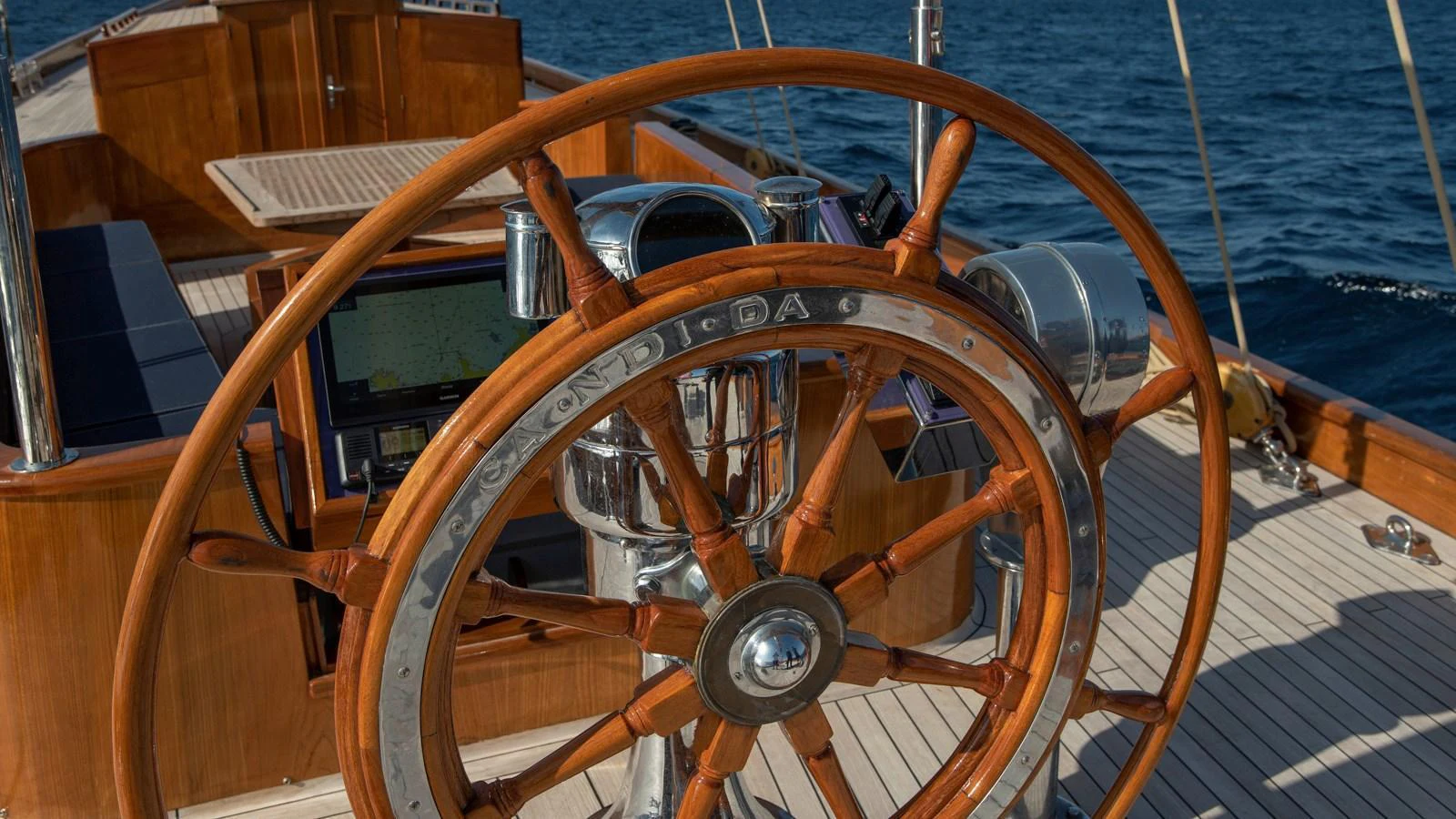 The image showcases the beautifully crafted wooden helm of a yacht, highlighting its intricate design and craftsmanship. aboard CANDIDA Yacht for Sale