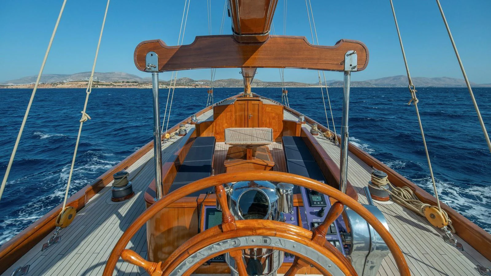 A classic wooden helm station with a panoramic view of the open sea. aboard CANDIDA Yacht for Sale