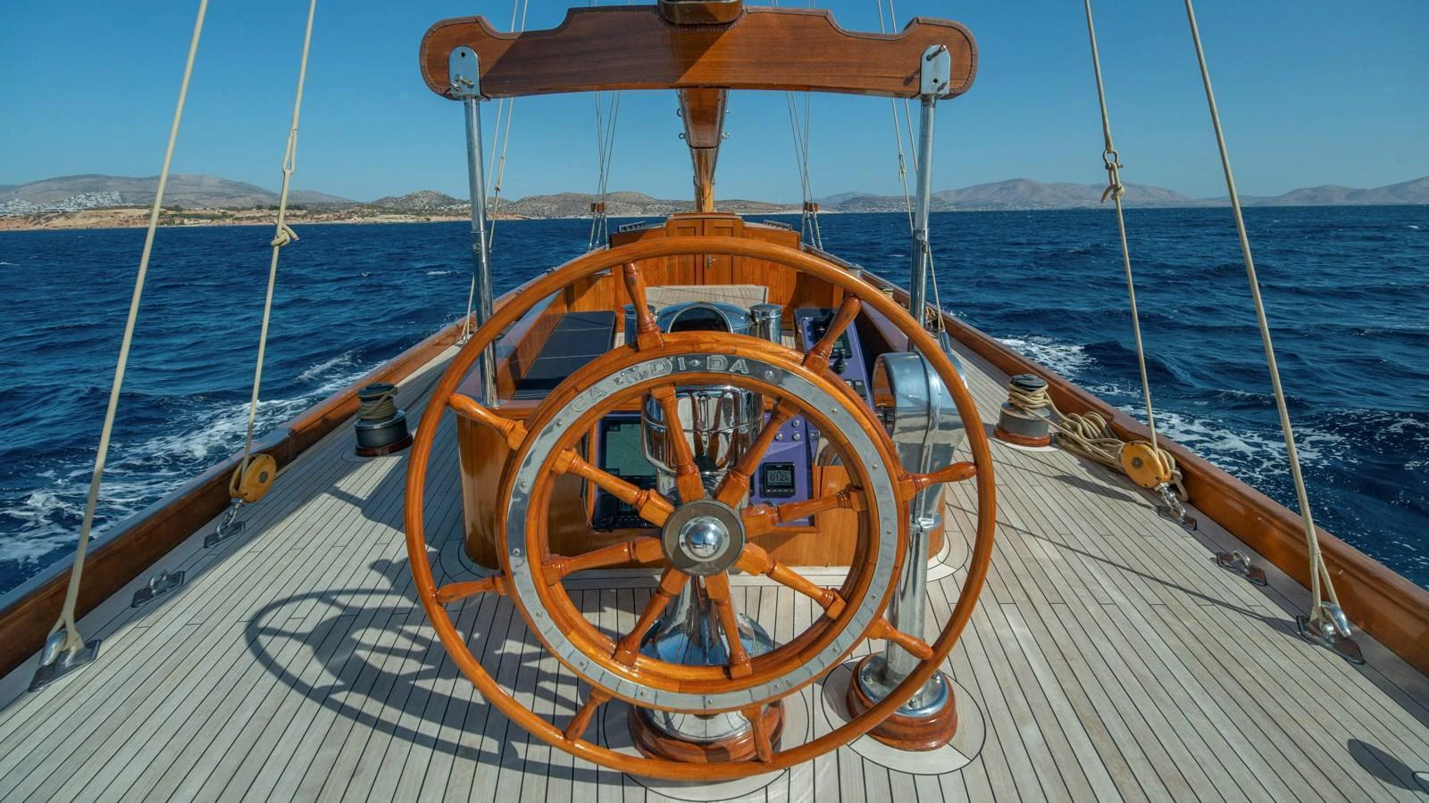 A classic wooden helm station on a sailing yacht with a view of the open sea. aboard CANDIDA Yacht for Sale