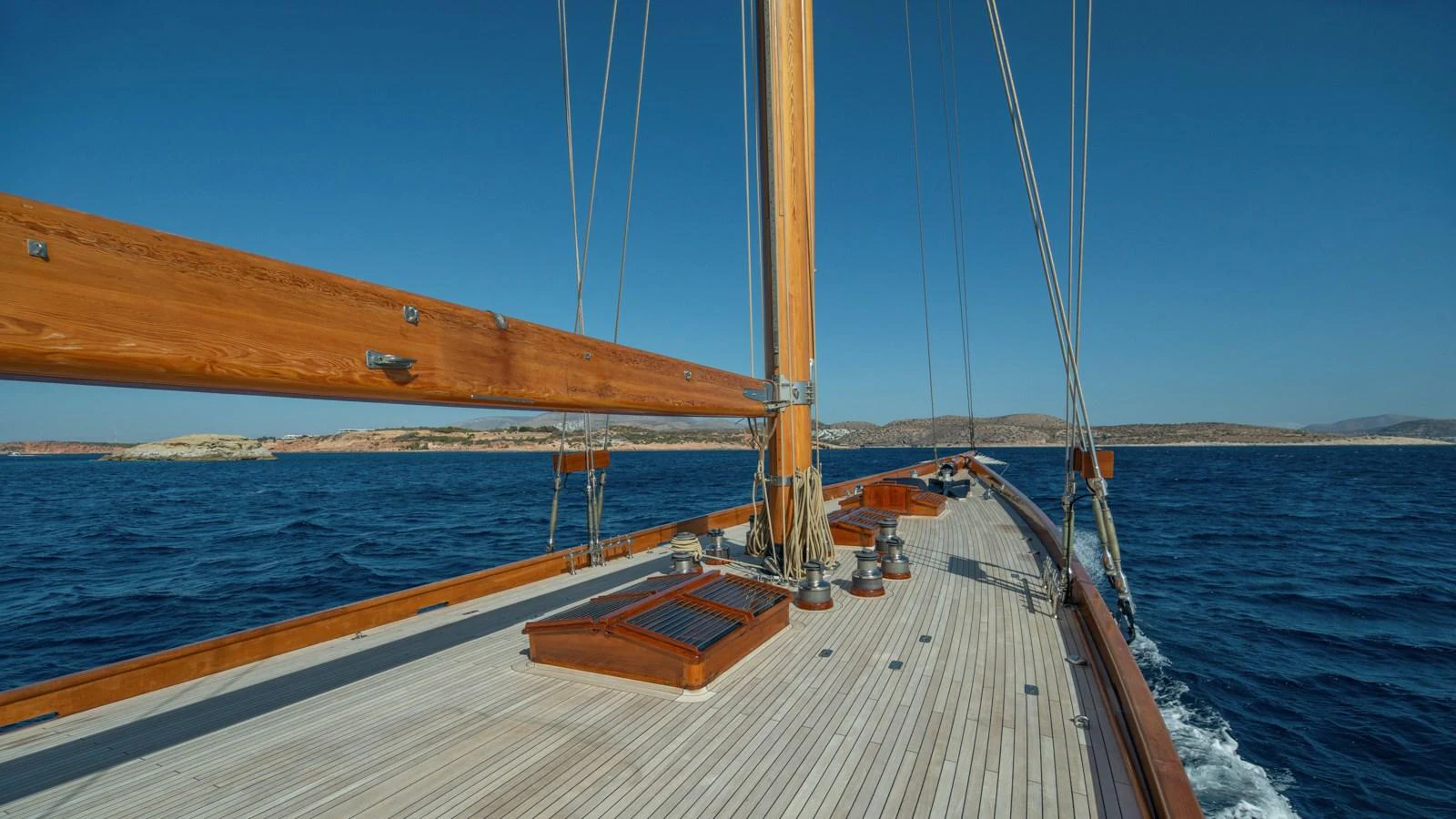 The yacht's deck showcases elegant wooden details and a serene ocean backdrop. aboard CANDIDA Yacht for Sale