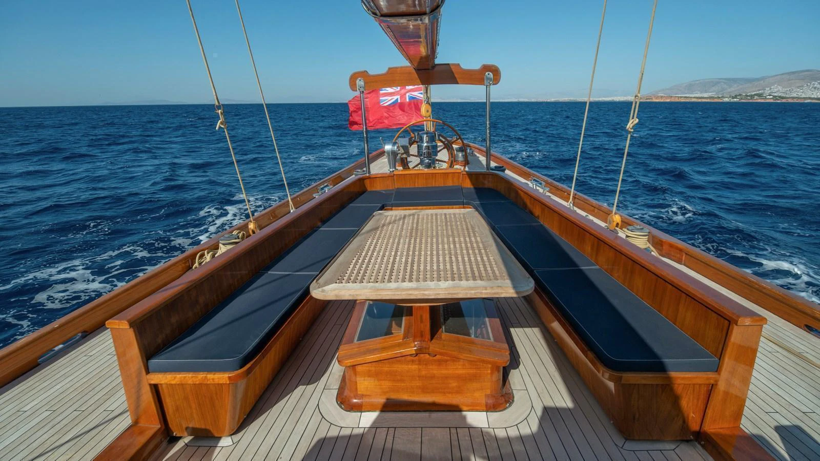The aft deck features a spacious seating area with a central table, perfect for alfresco dining while cruising. aboard CANDIDA Yacht for Sale