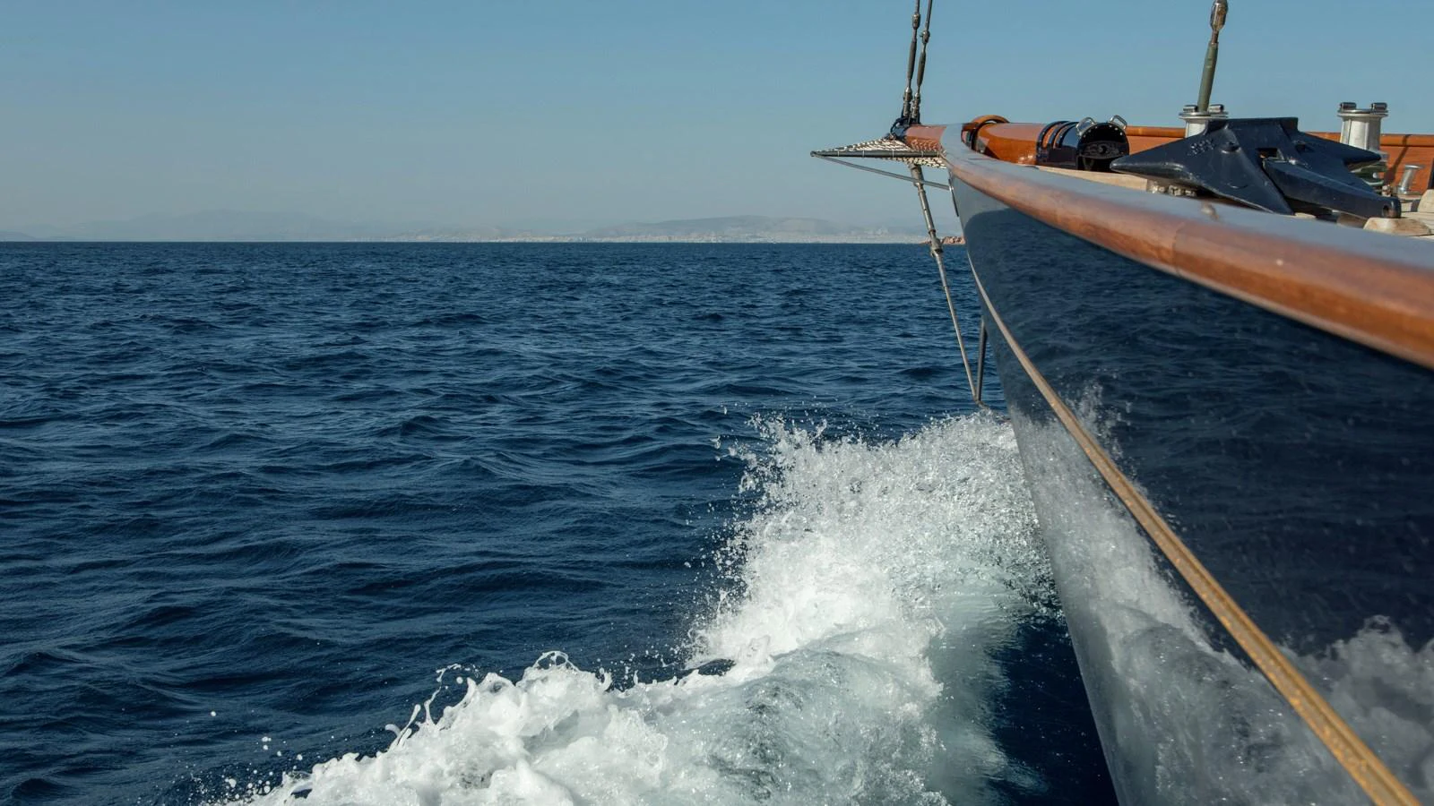 A sleek yacht glides through the open sea, creating a beautiful wake. aboard CANDIDA Yacht for Sale