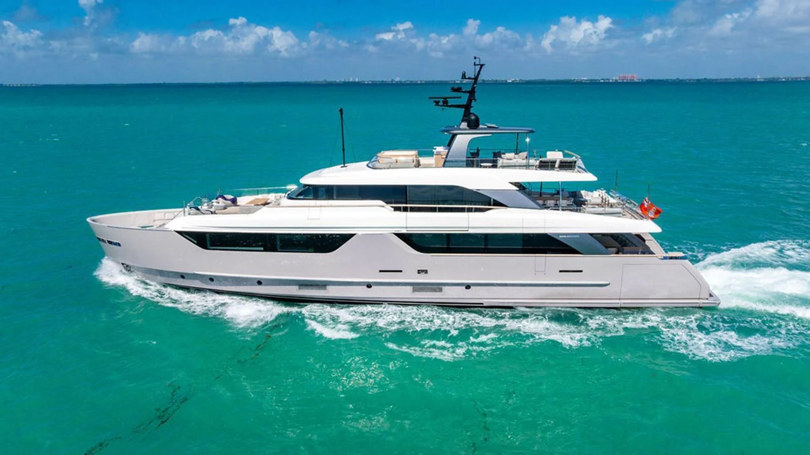 A sleek and modern yacht cruising on turquoise waters under a clear blue sky. aboard SANLORENZO SD118/129 Yacht for Sale