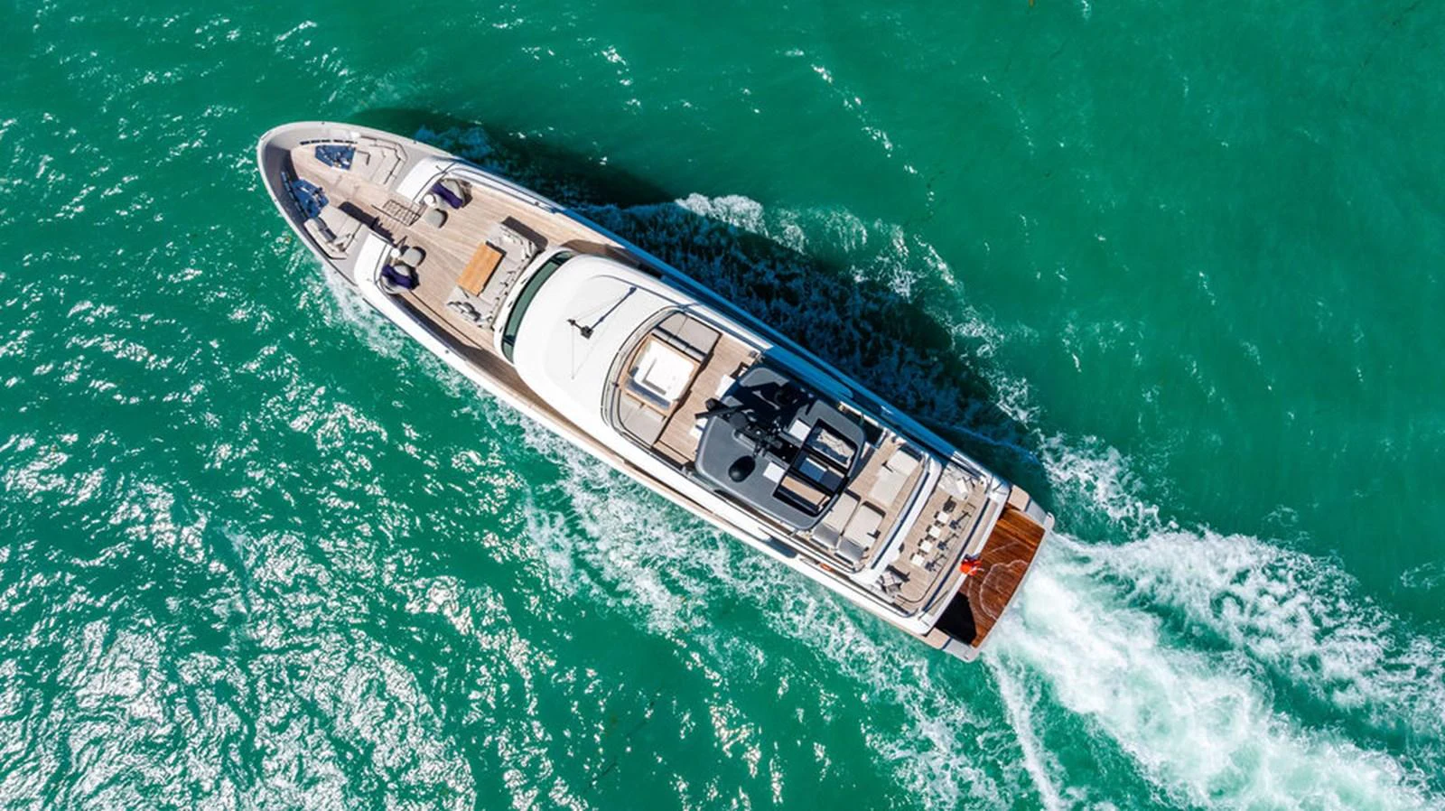 A stunning aerial view of a luxurious yacht cruising through vibrant turquoise waters. aboard SANLORENZO SD118/129 Yacht for Sale