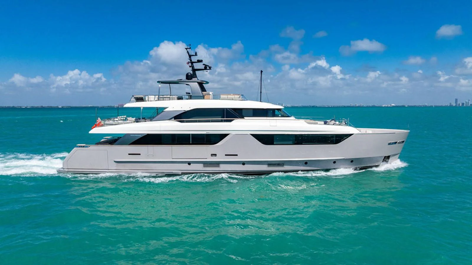 A sleek and modern yacht cruises through turquoise waters under a clear blue sky. aboard SANLORENZO SD118/129 Yacht for Sale