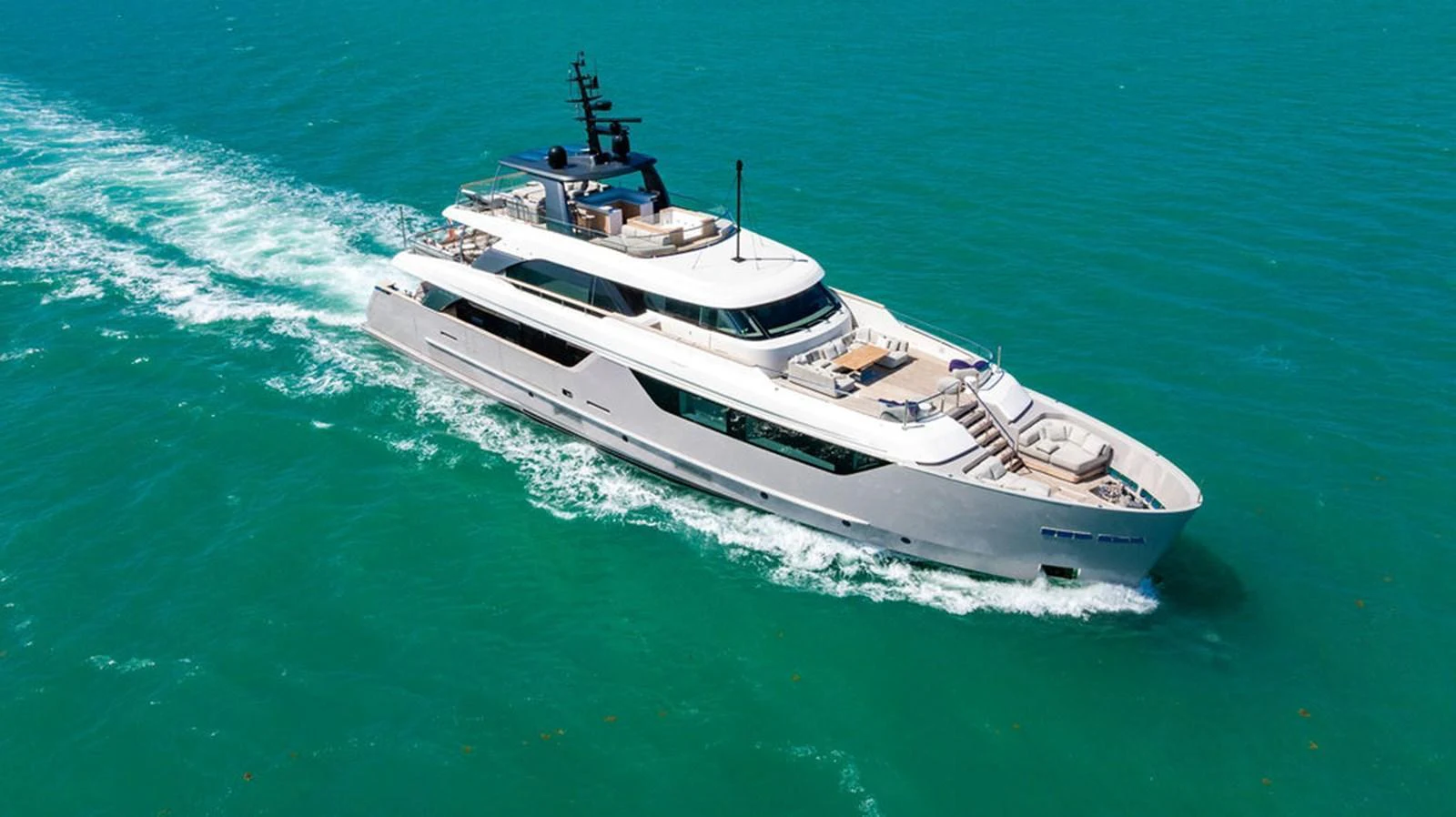 A sleek and modern yacht cruises through clear turquoise waters, showcasing its elegant design and spacious decks. aboard SANLORENZO SD118/129 Yacht for Sale