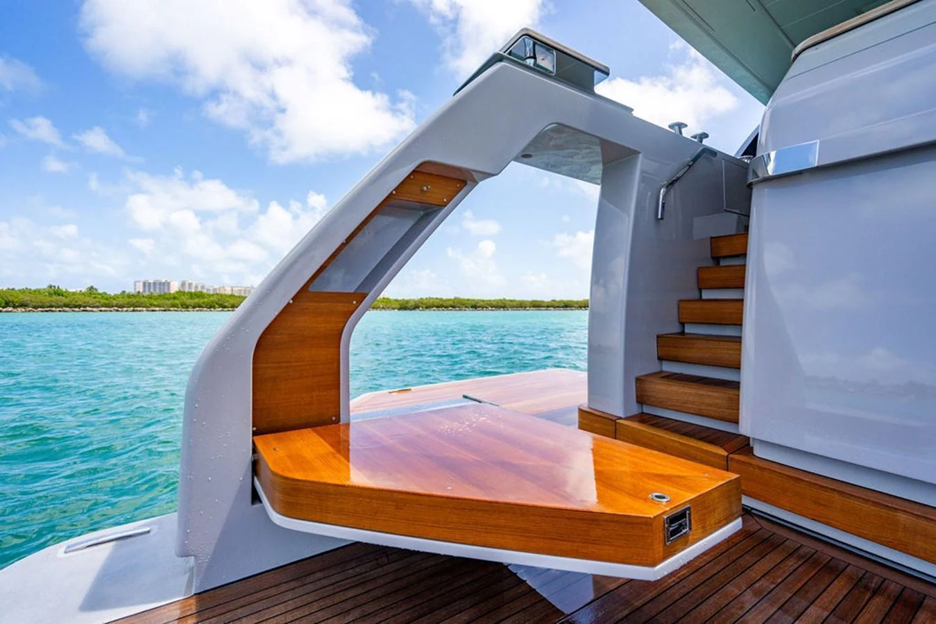 A sleek and modern yacht exterior featuring a stylish staircase and wooden deck against a serene water backdrop. aboard SANLORENZO SD118/129 Yacht for Sale