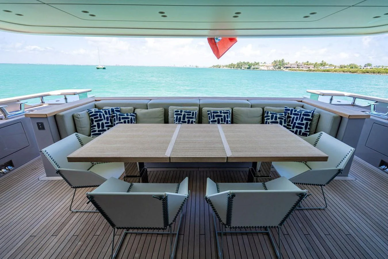The aft deck features a spacious dining area with a large table and comfortable seating, offering stunning views of the surrounding waters. aboard SANLORENZO SD118/129 Yacht for Sale