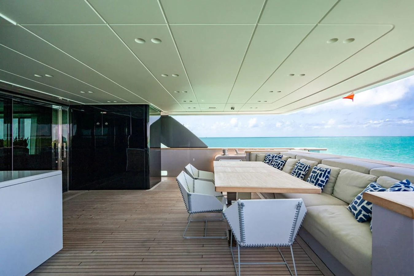 The aft deck features a spacious seating area with a dining table, perfect for alfresco meals with a view of the sea. aboard SANLORENZO SD118/129 Yacht for Sale